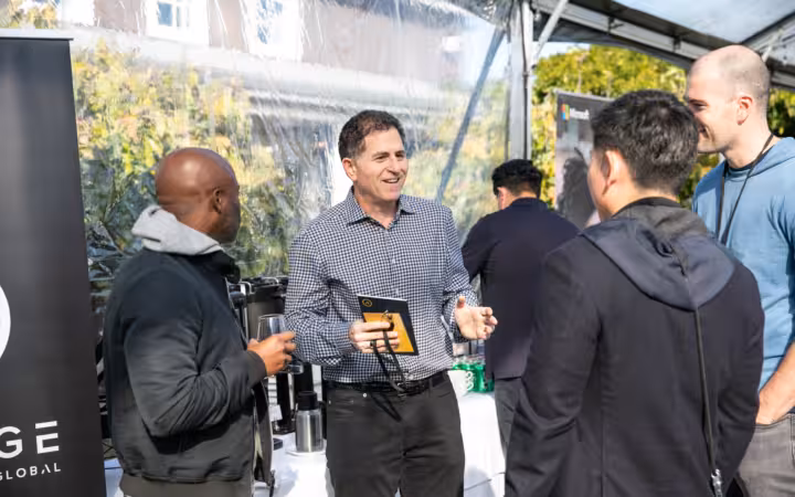 Michael Dell speaks with several people beneath a canopy at The Grove.