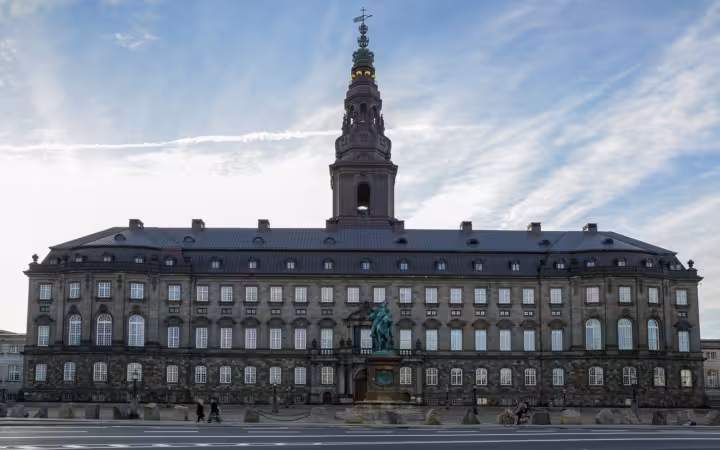 Christiansborg Palace in Copenhagen, with its central tower and statue outside.