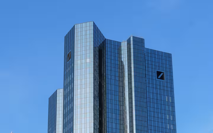 Deutsche Bank headquarters in Frankfurt, glass towers against a clear blue sky