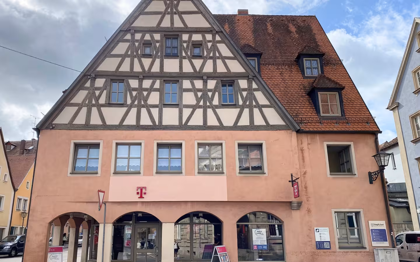 A Deutsche Telekom building with a half-timbered facade and magenta logos