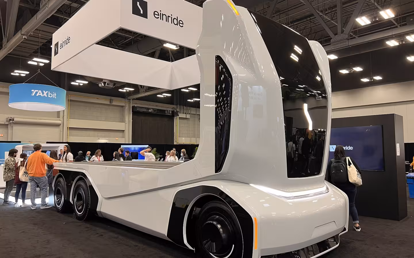 An Einride self-driving truck displayed beneath company signage at an exhibition.