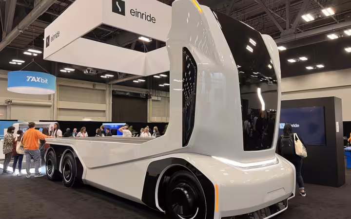 An Einride self-driving truck displayed beneath company signage at an exhibition.