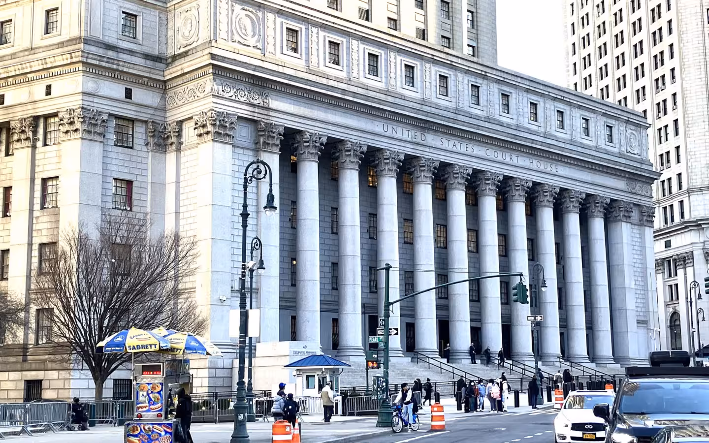 The Thurgood Marshall United States Courthouse, with columns, pedestrians and street traffic.