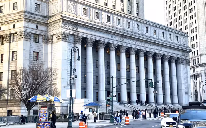 The Thurgood Marshall United States Courthouse, with columns, pedestrians and street traffic.