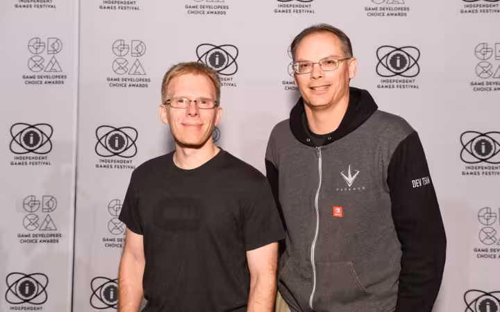 John Carmack and Tim Sweeney posing together before a games awards backdrop