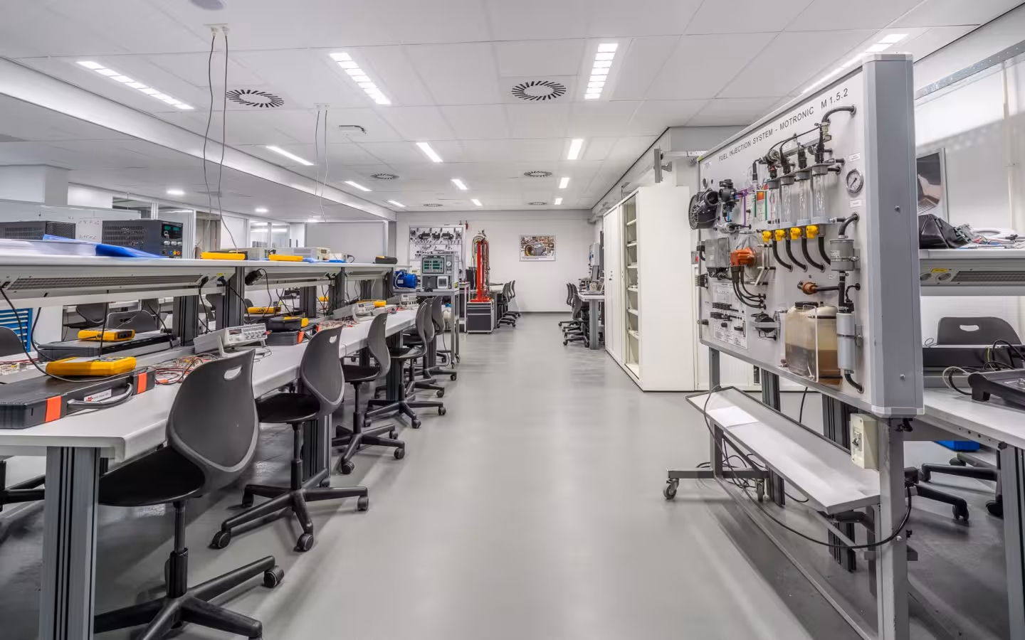 A bright, empty laboratory with workstations, chairs and testing equipment.