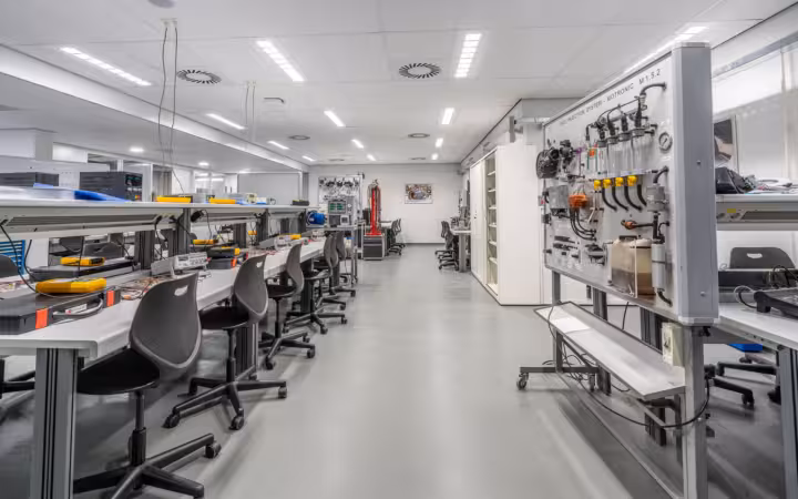 A bright, empty laboratory with workstations, chairs and testing equipment.