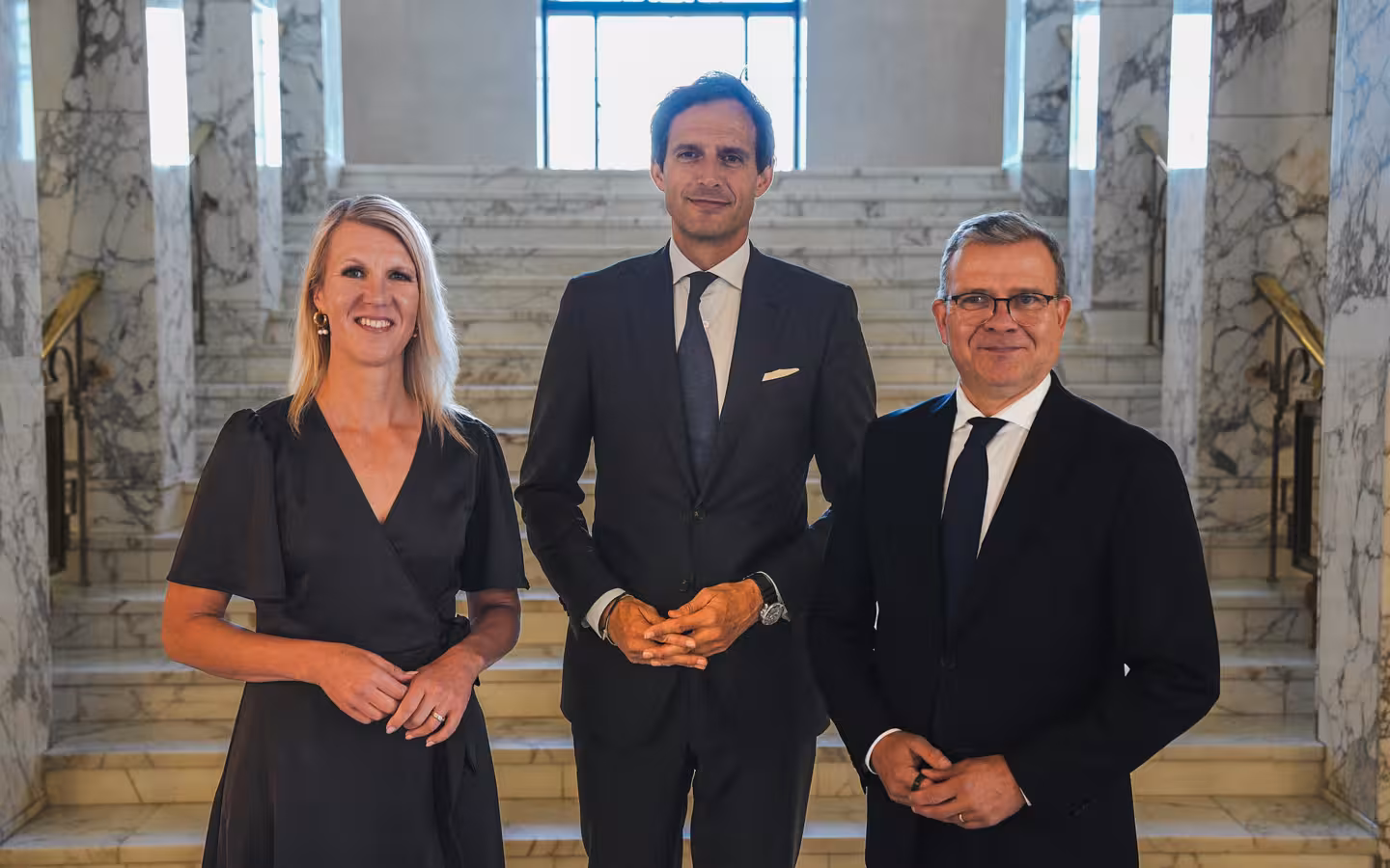 Sari Multala, Wopke Hoekstra and Petteri Orpo pose on marble stairs.