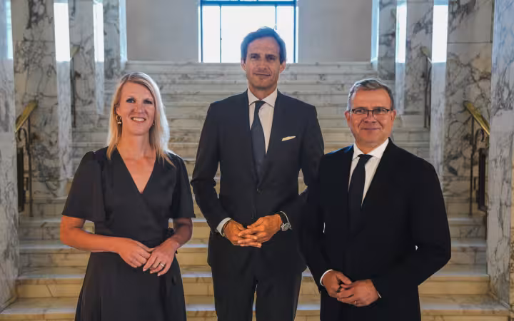 Sari Multala, Wopke Hoekstra and Petteri Orpo pose on marble stairs.