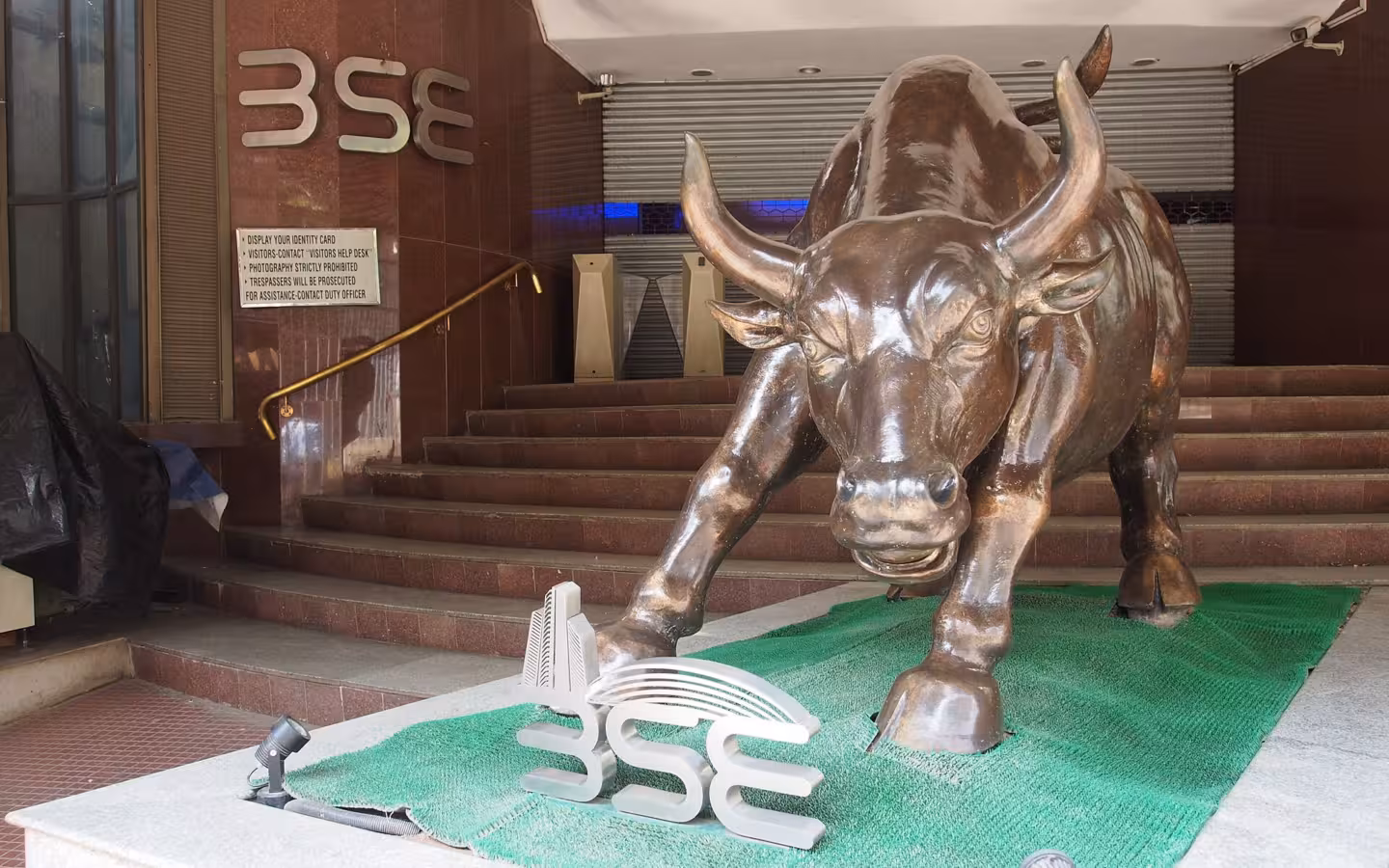 Bronze bull statue outside the Bombay Stock Exchange, with BSE signs visible.