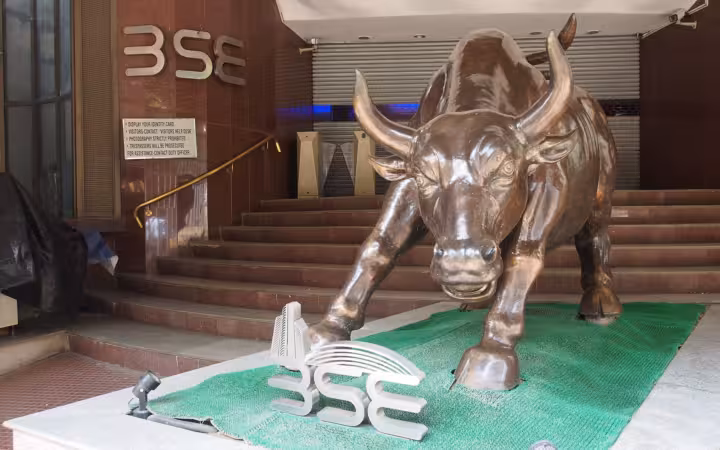Bronze bull statue outside the Bombay Stock Exchange, with BSE signs visible.