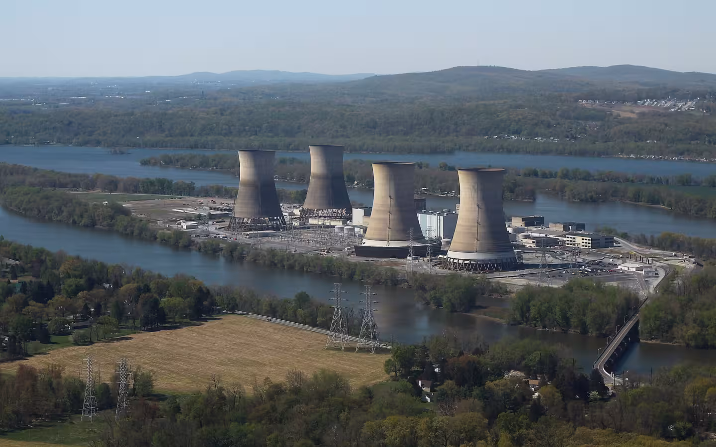 Four cooling towers at Three Mile Island Nuclear Generating Station beside a river