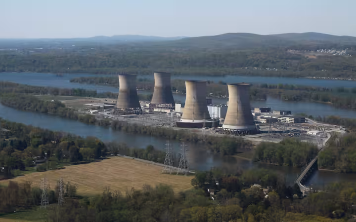 Four cooling towers at Three Mile Island Nuclear Generating Station beside a river