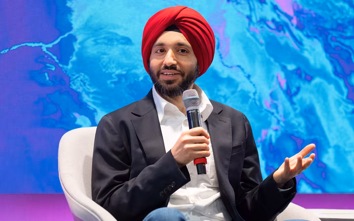 Pushmeet Kohli speaks into a microphone against a colourful backdrop at SXSW London 2026
