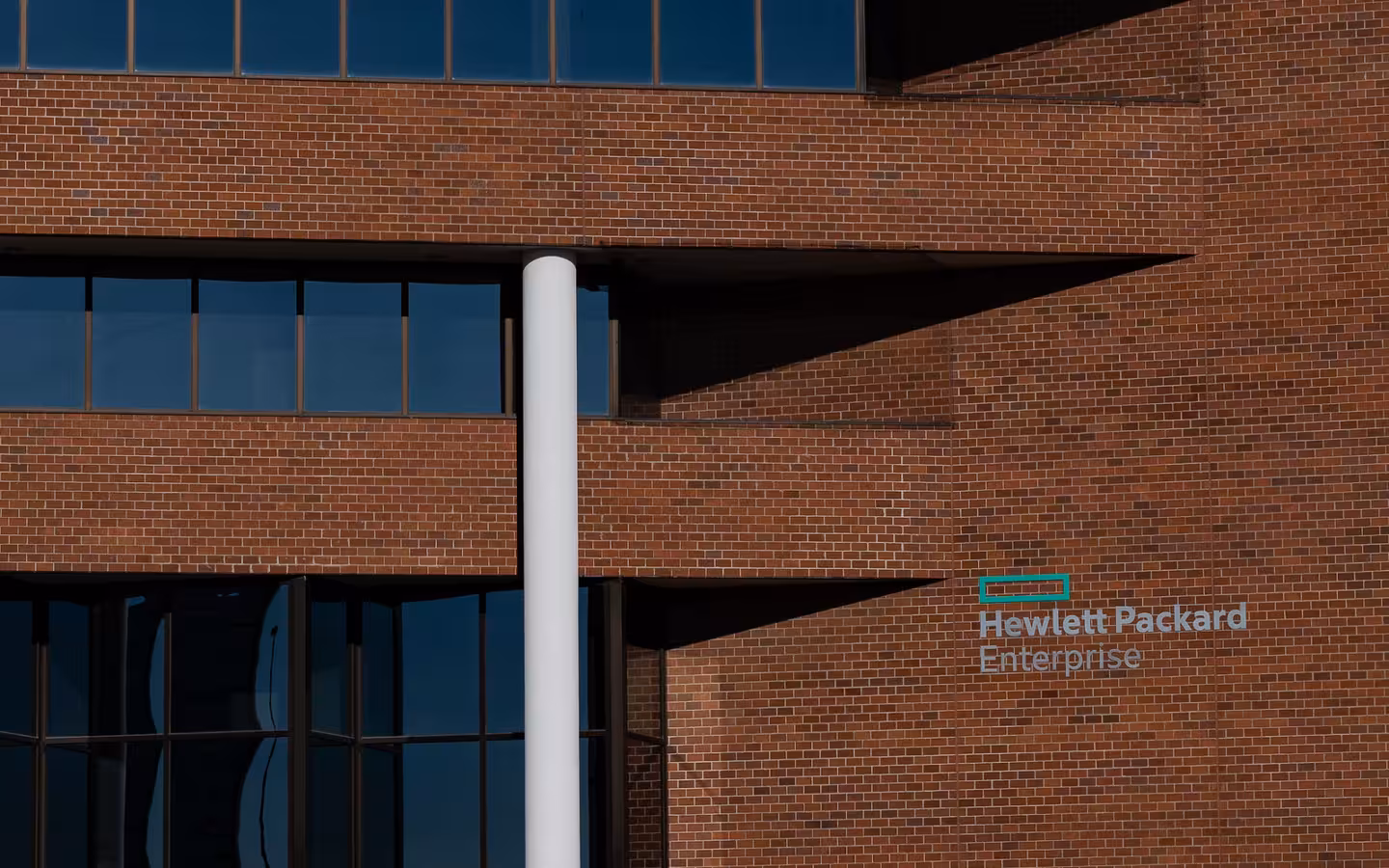 Hewlett Packard Enterprise office building in Omaha, with its logo on a brick wall