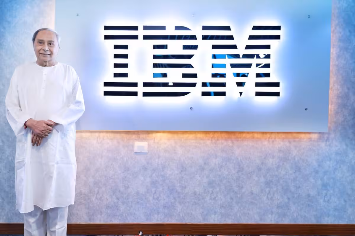 Odisha CM stands beside an illuminated IBM sign at its Bhubaneswar office.