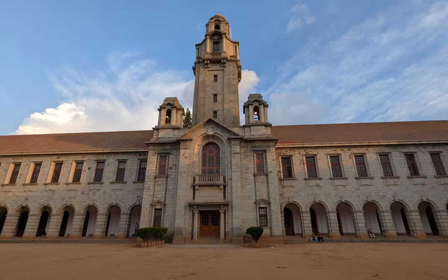 The main building of IISc Bengaluru beneath a partly cloudy sky