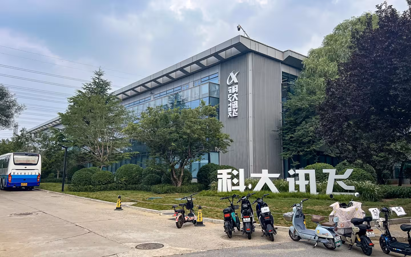 Beijing iFLYTEK Building behind trees, with scooters parked outside.