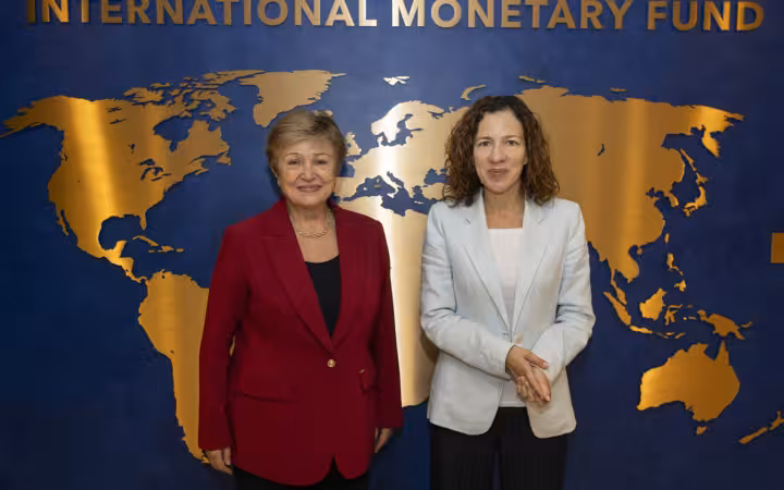 Kristalina Georgieva and Roxana Mînzatu pose before an International Monetary Fund backdrop.