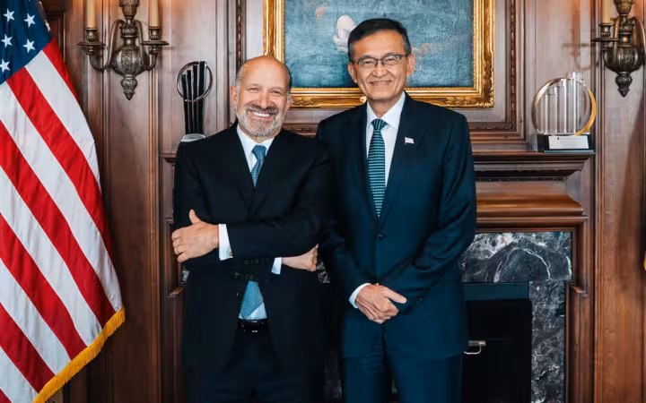 Howard Lutnick and Intel CEO Lip-Bu Tan pose beside an American flag.