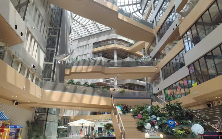 Sunlit atrium with walkways, stairs and plants at Alibaba Chaoyang Technology Park