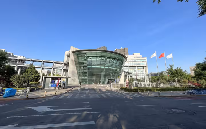 Kuaishou headquarters’ glass-fronted west gate across a road beneath blue sky