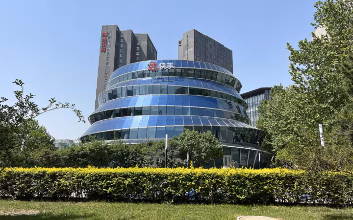 Kuaishou office building with its logo above a landscaped hedge