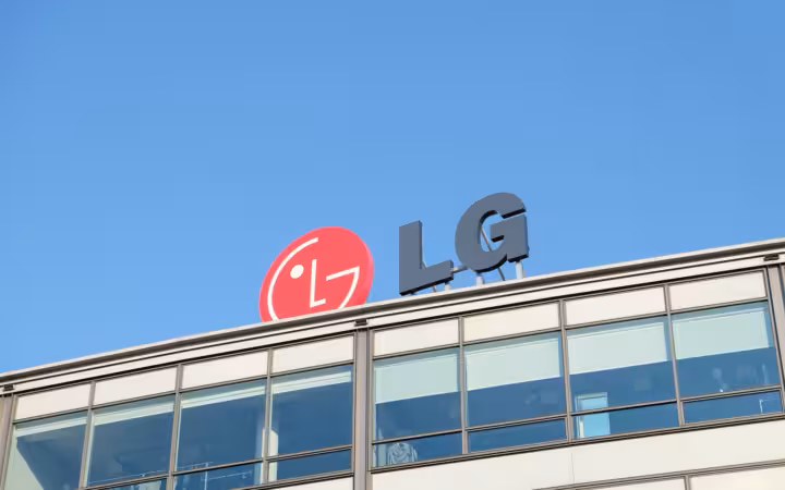 LG logo rises above an office building beneath a clear blue sky
