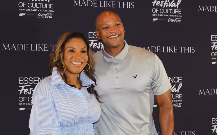 Governor Wes Moore and First Lady Dawn Moore posing together against a backdrop.