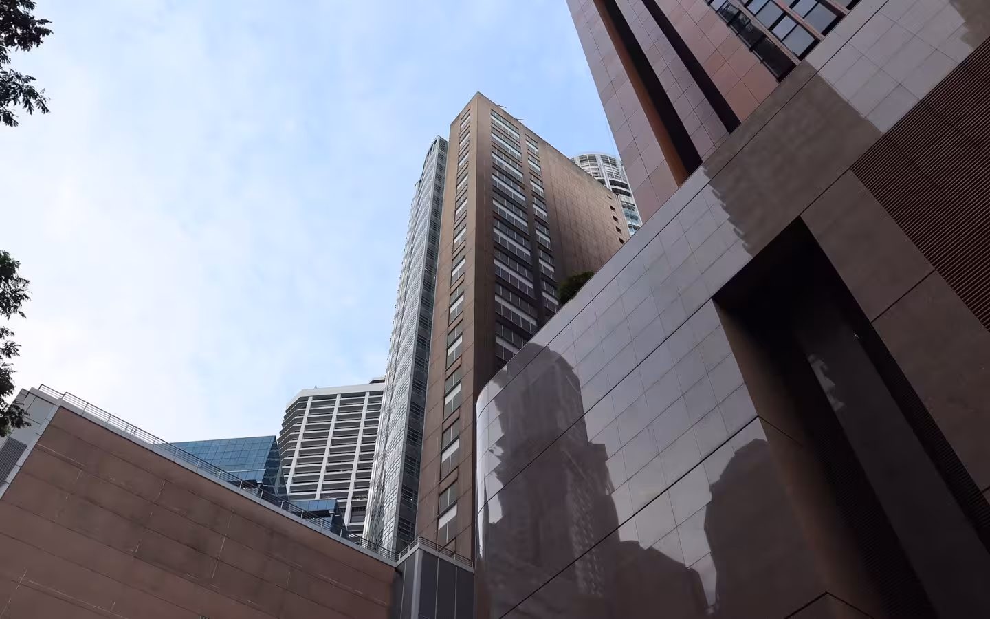 A low-angle view of the Monetary Authority of Singapore building amid other towers