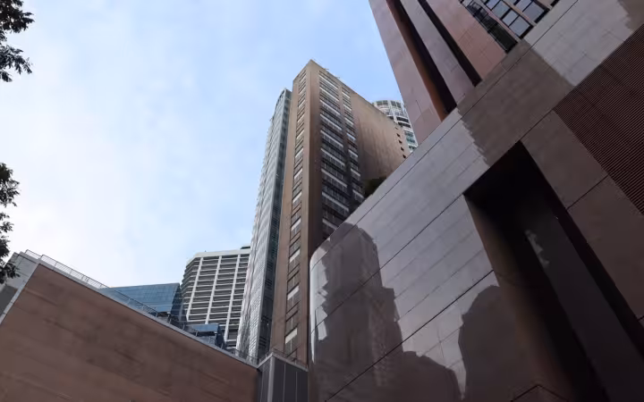 A low-angle view of the Monetary Authority of Singapore building amid other towers