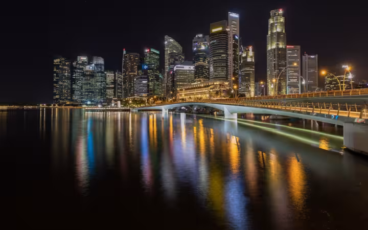 Singapore’s Central Business District skyline and Esplanade Bridge reflected in water at night