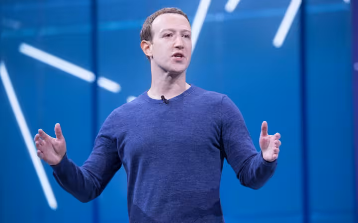 Mark Zuckerberg speaking on stage with blue background during F8 2018