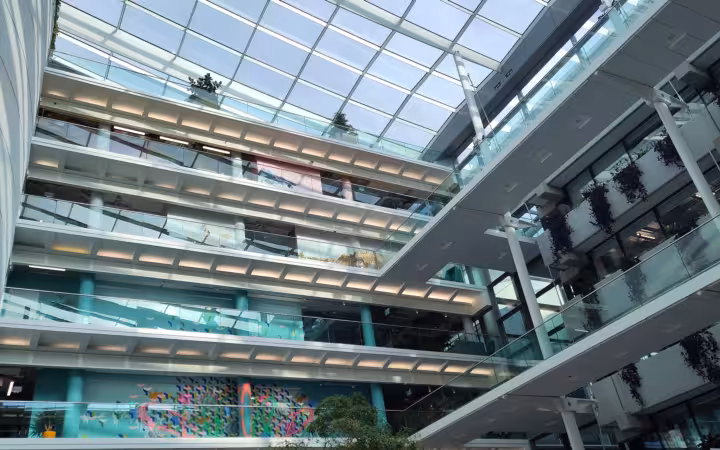 Sunlit atrium inside Meta’s Dublin offices, with glass walkways and balconies