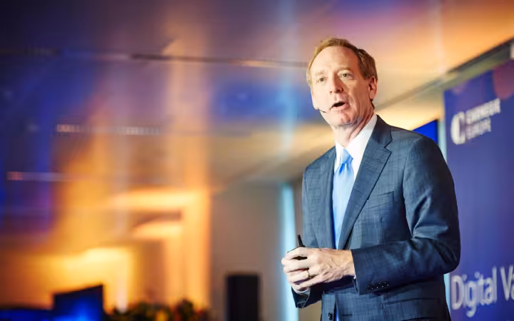 Brad Smith speaking in a suit against a Digital Values backdrop
