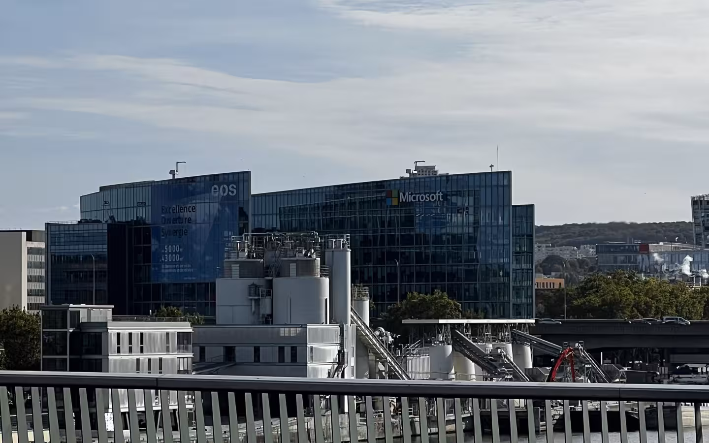 Microsoft France headquarters behind industrial structures and a foreground railing