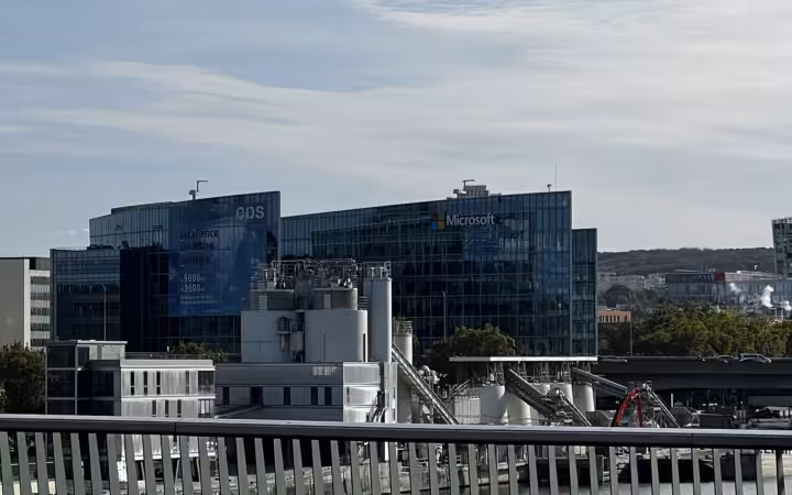 Microsoft France headquarters behind industrial structures and a foreground railing