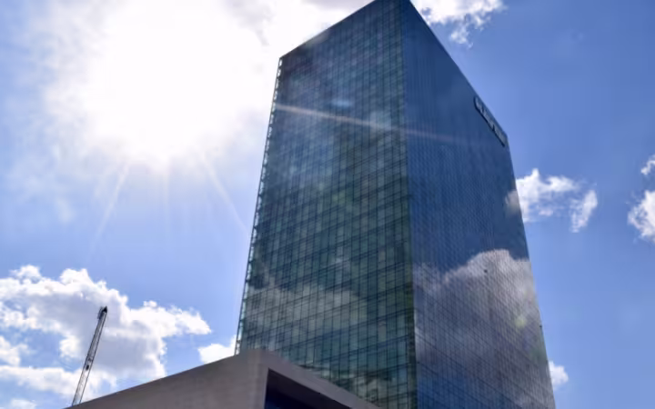 Naver’s Green Factory headquarters rises against a bright, partly cloudy sky.