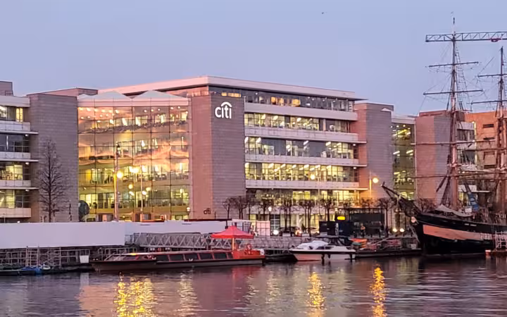 Citi Europe headquarters in Dublin beside boats on a waterfront at dusk