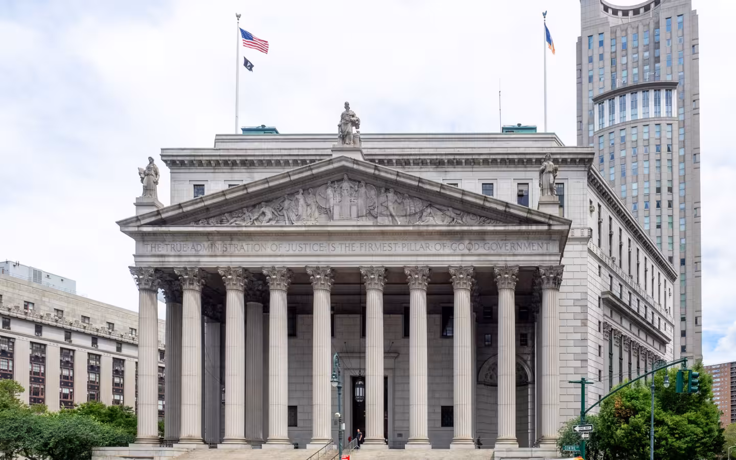 The New York County Courthouse’s columned facade rises above traffic on Foley Square.
