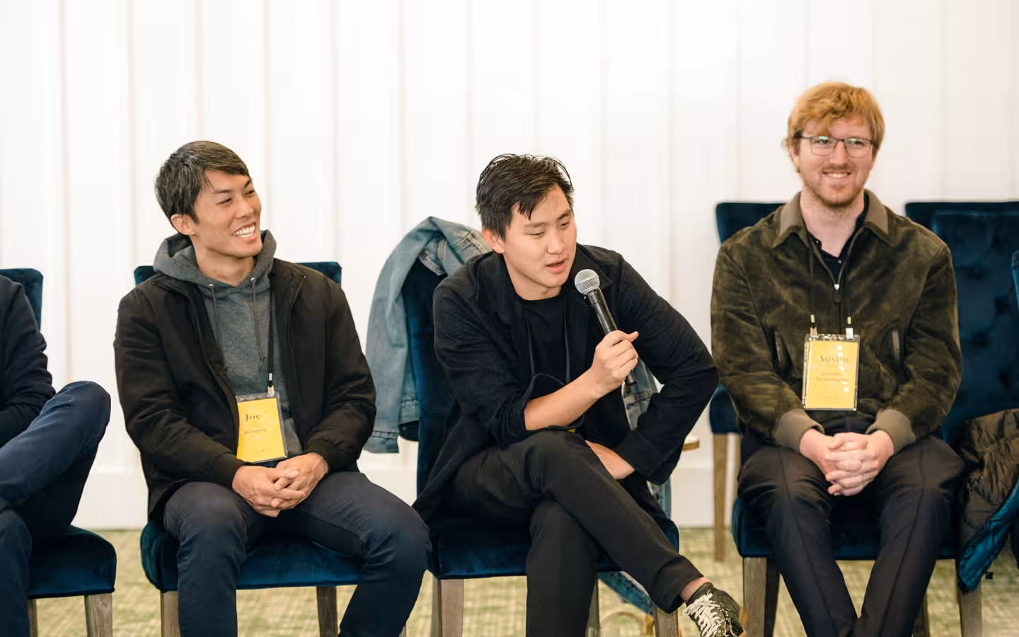 Alexandr Wang among seated panelists, one speaking into a microphone.