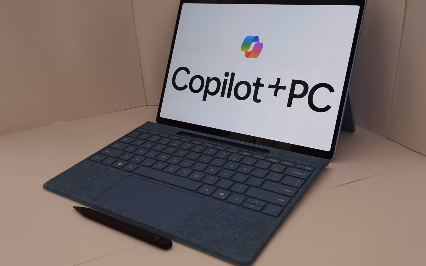 An AI PC with a keyboard and stylus displays the Copilot+ PC logo.