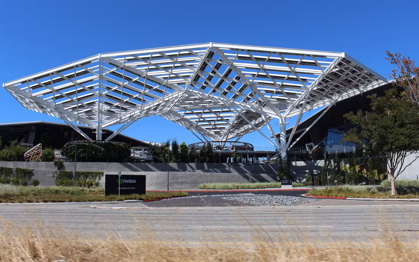 Nvidia headquarters entrance beneath a broad white canopy on a sunny day