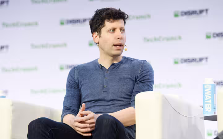 Sam Altman speaks onstage seated in a white chair at an event.