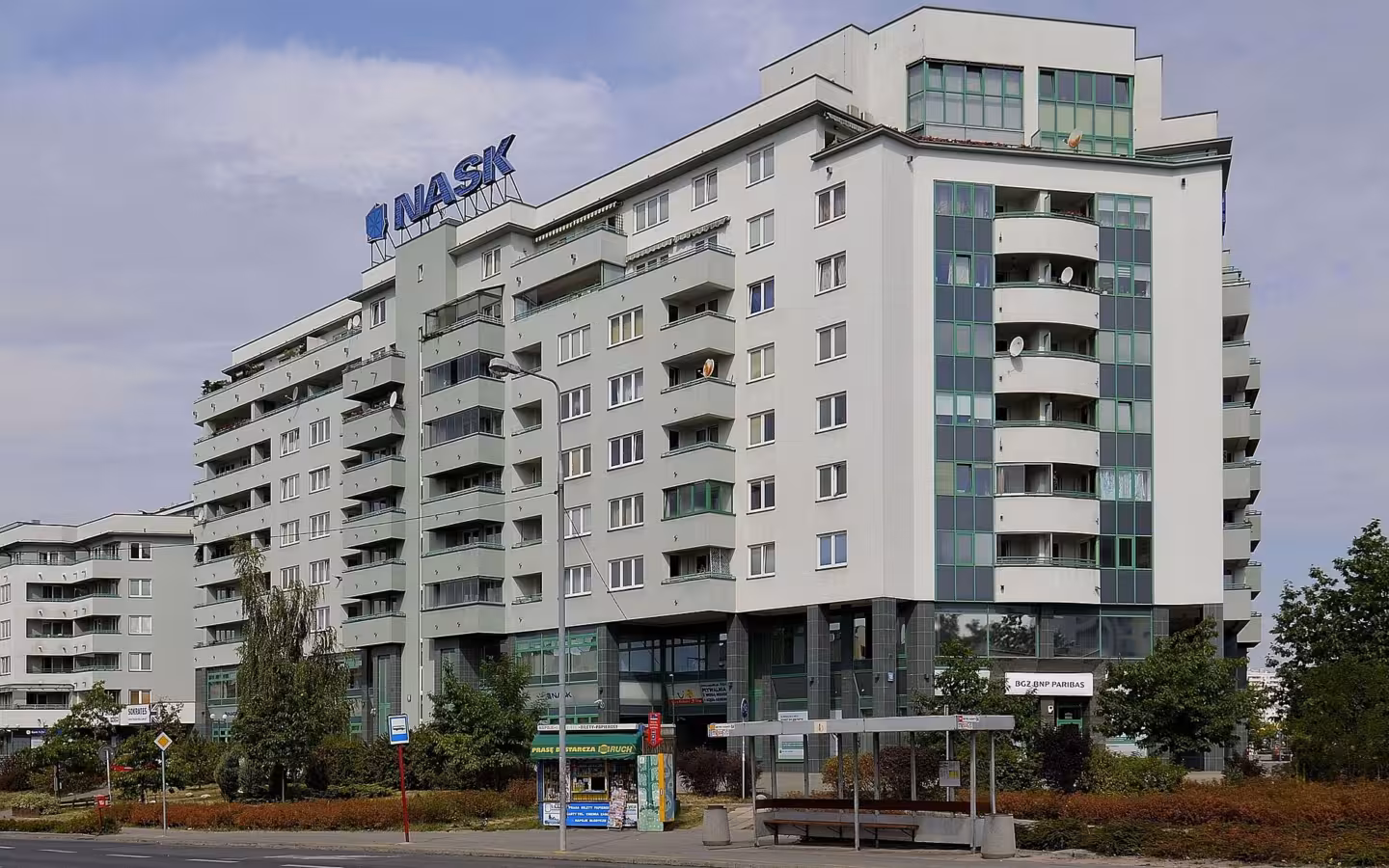 NASK headquarters on Wąwozowa Street in Warsaw, with balconies and a bus shelter