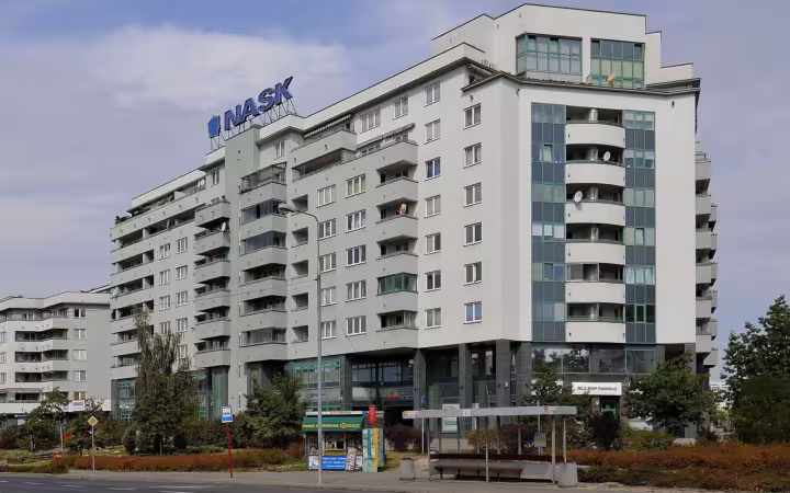 NASK headquarters on Wąwozowa Street in Warsaw, with balconies and a bus shelter