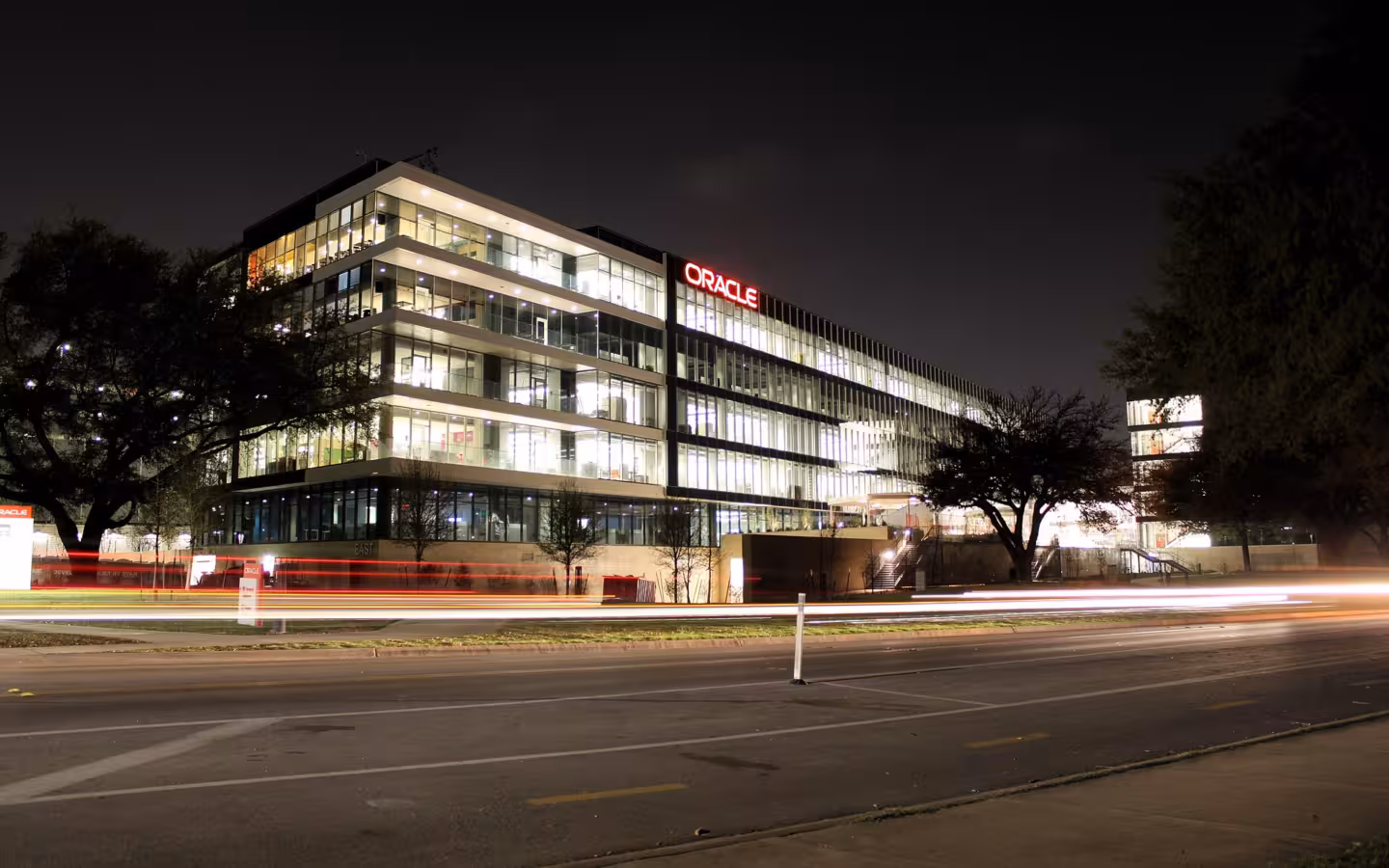 Oracle Riverside Campus illuminated at night across a road in Austin, Texas