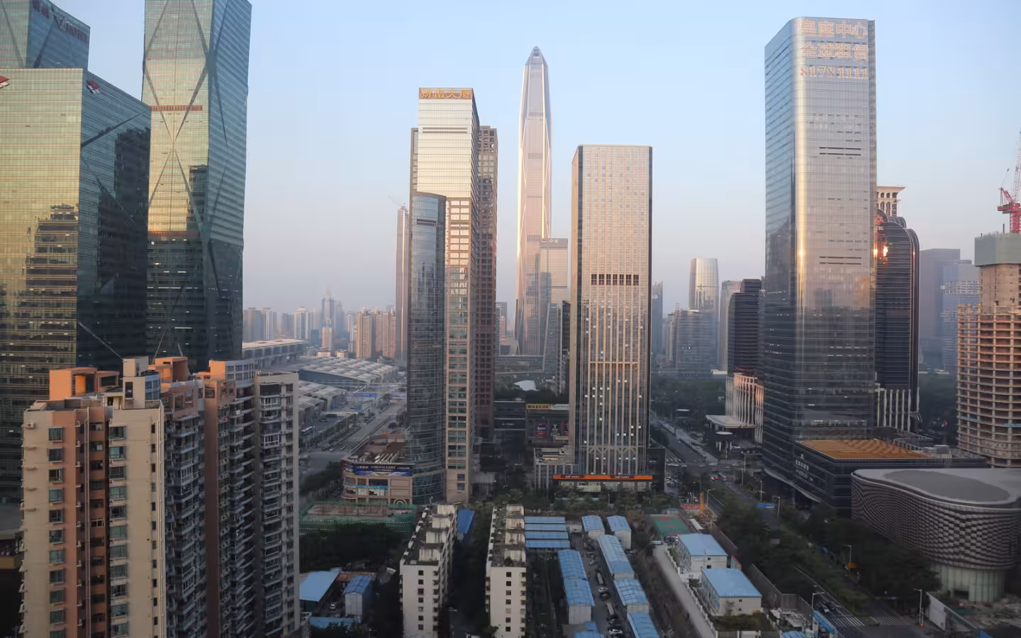 High-rise buildings and streets in Shenzhen, China, under a pale sky