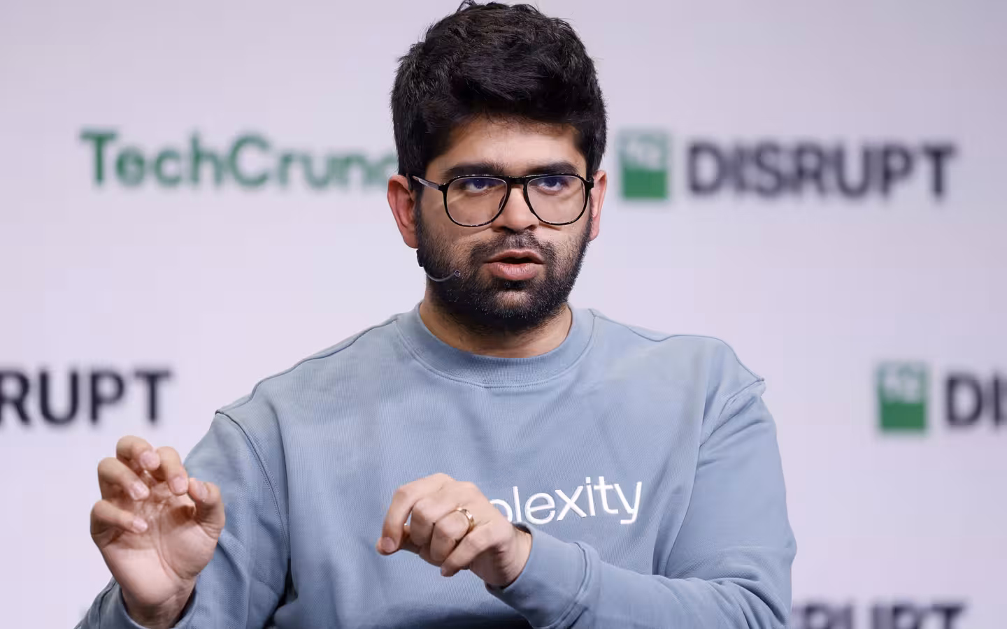 Aravind Srinivas speaks onstage in front of TechCrunch Disrupt branding.