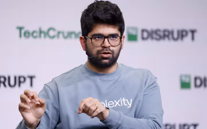 Aravind Srinivas speaks onstage in front of TechCrunch Disrupt branding.